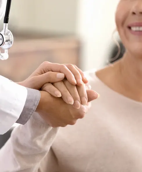 Female doctor holding female patient’s hand