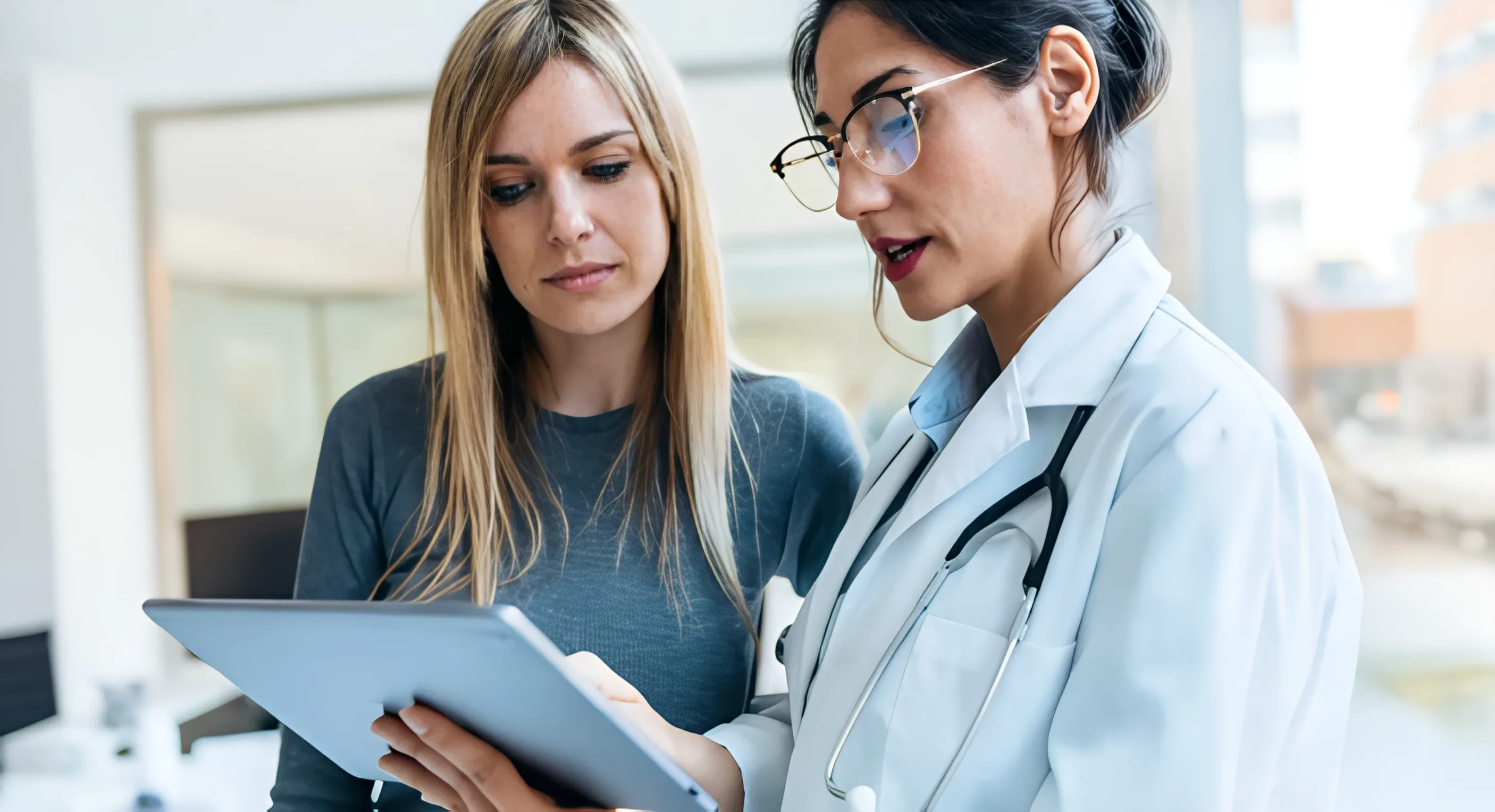 Two women reading a tablet and talking